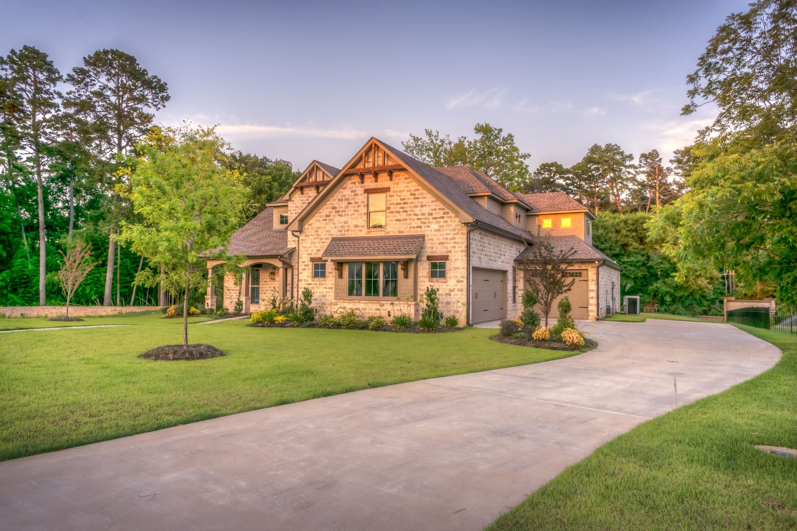 A manicured green lawn and trees framing a Southern Utah home at golden hour