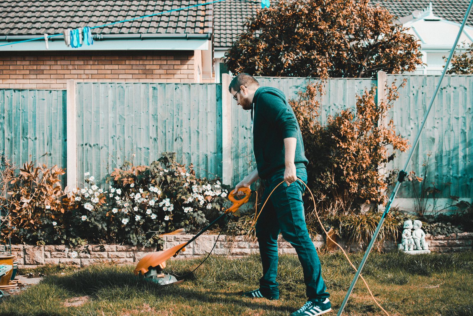 A 4-Seasons crew member edging and trimming the borders of a flower bed